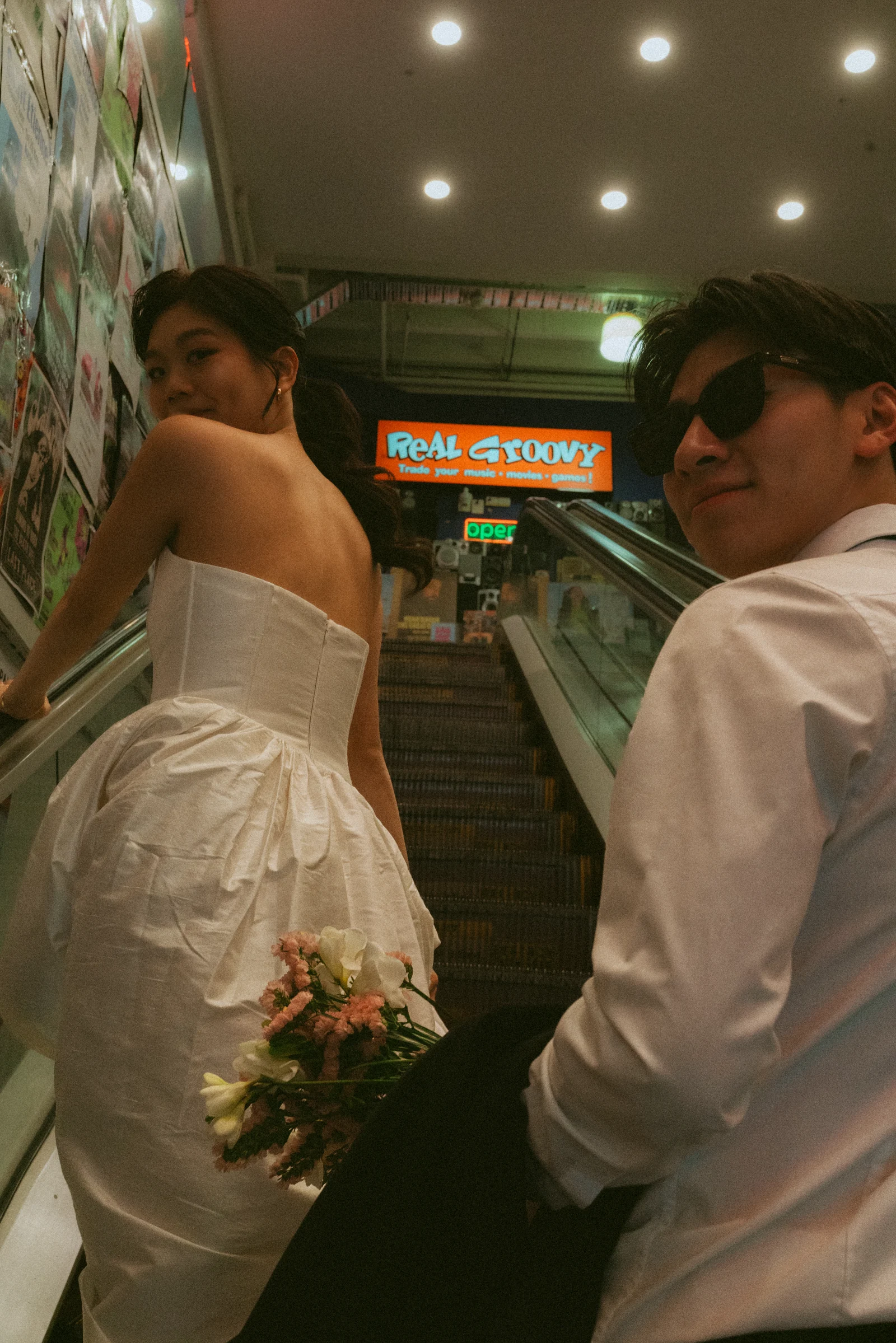 Emily and Benny looking back on an escalator at Real Groovy